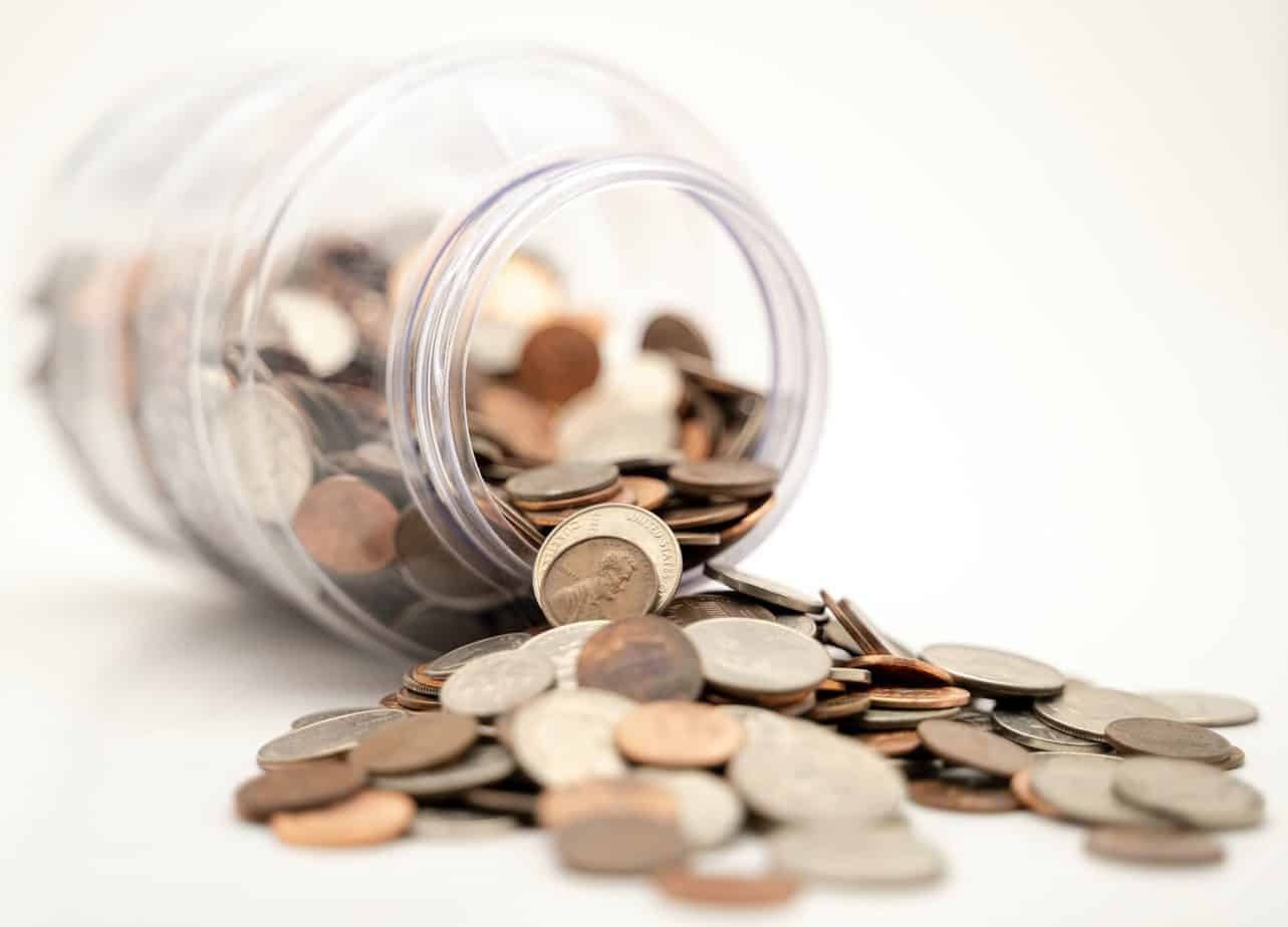 Money saving jar - coins flooding out of the jar